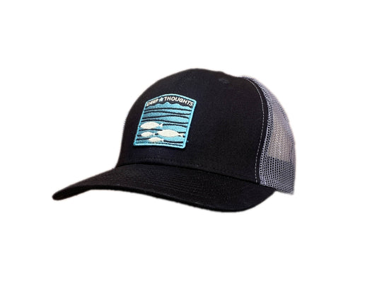 Black and grey trucker cap with embroidered blue white and grey fish under waves patch