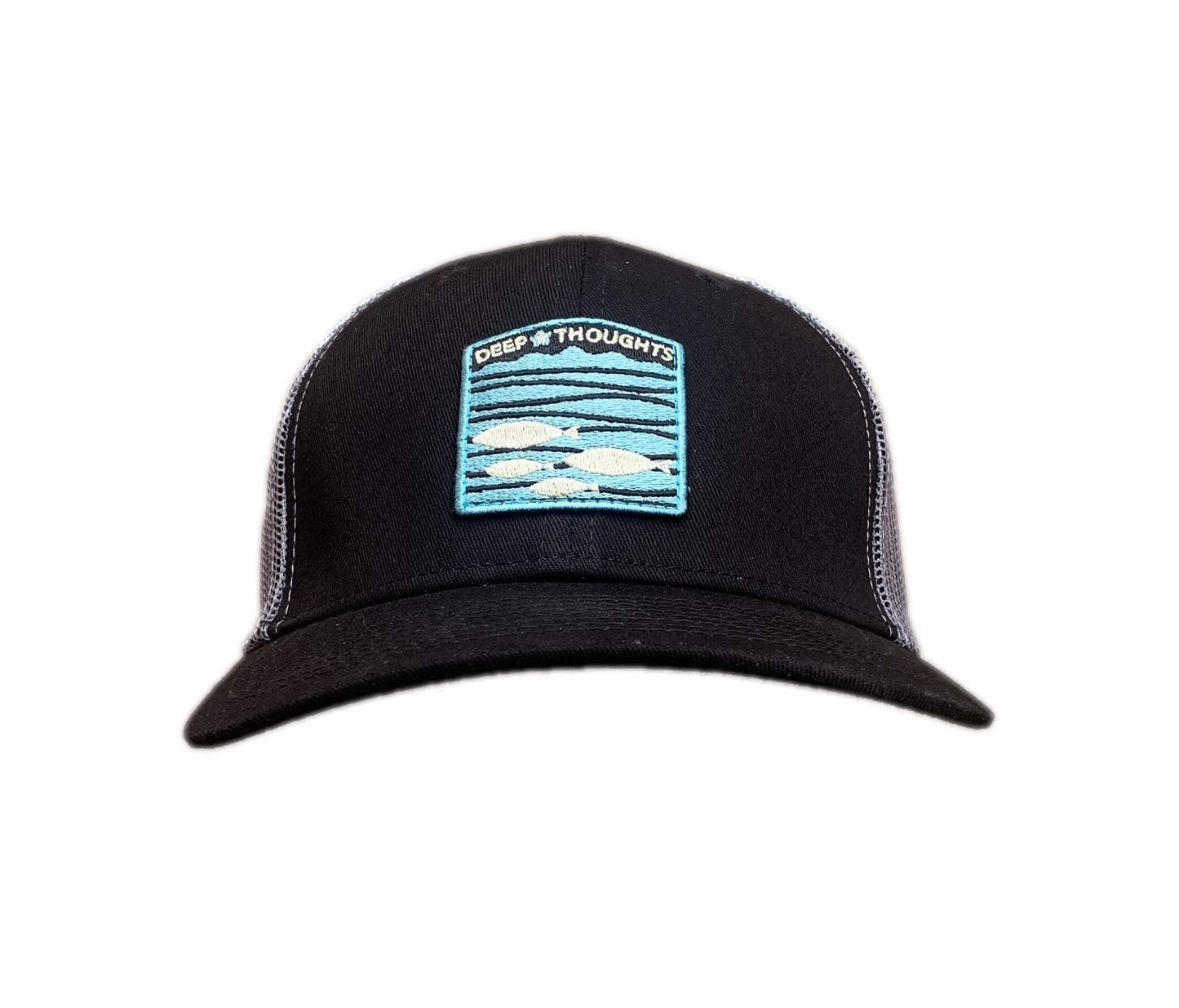 Front view of black and grey trucker cap with blue and orange embroidered fish under waves patch